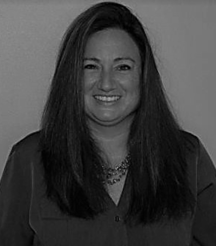 Meet Our Team - Professional and Welcoming Group at a Conference Table Faces the Camera, Team Leader Sitting on the Table with Arms Folded
